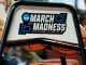 a metal chair with a March Madness logo on the back