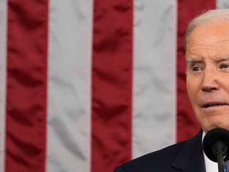 President Biden delivering the State of the Union in front of an American flag