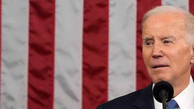 President Biden delivering the State of the Union in front of an American flag