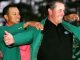 Tiger Woods putting a green jacket on Phil Mickelson at The Masters